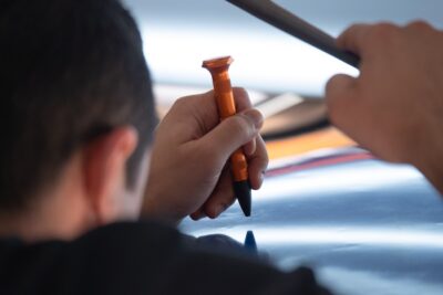 Tapping dents in paintless dent removal training